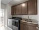 Laundry room includes a sink, granite counters, and ample cabinetry above the washer and dryer at 4800 Gablestone Xing, Hoschton, GA 30548