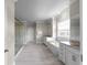 Spacious bathroom with a soaking tub, glass shower, dual vanities, and tiled floor at 4800 Gablestone Xing, Hoschton, GA 30548