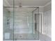 Modern glass shower enclosure featuring dual shower heads, tiled walls, and a built-in bench at 4800 Gablestone Xing, Hoschton, GA 30548