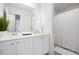 Well-lit bathroom featuring a double sink vanity, a large mirror, and a shower with a white shower curtain at 7161 Gladstone Cir, Lithonia, GA 30038