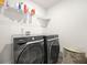 Modern laundry room with front-load washer and dryer, overhead shelving, and a neat, organized setup for convenience at 7161 Gladstone Cir, Lithonia, GA 30038