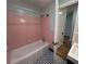 Vintage pink tiled bathroom with shower and updated patterned tile flooring at 779 Casplan Sw St, Atlanta, GA 30310
