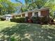 Quaint brick home with white shutters surrounded by green lawn and mature landscaping at 779 Casplan Sw St, Atlanta, GA 30310