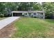 Beautiful single-story house with a long driveway, carport, manicured lawn, and mature trees at 830 Lee Nw Dr, Marietta, GA 30060