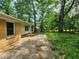 Backyard concrete patio with a view of the lawn and surrounding trees, and brick house elevation at 1321 Snapfinger Rd, Decatur, GA 30032