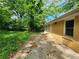 View of backyard with concrete patio and brick elevation of house, lush trees at 1321 Snapfinger Rd, Decatur, GA 30032