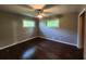 Well-lit bedroom with hardwood floors, a ceiling fan, and natural light from two windows at 1321 Snapfinger Rd, Decatur, GA 30032