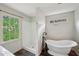 This bathroom features a freestanding tub, a separate shower, and a bright window at 2650 Wendell Creek Ln, Snellville, GA 30039