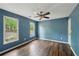 Blue bedroom featuring hardwood floors, a ceiling fan, and two windows at 2650 Wendell Creek Ln, Snellville, GA 30039