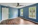 This bedroom features hardwood floors, a ceiling fan, and two windows allowing for ample natural light at 2650 Wendell Creek Ln, Snellville, GA 30039