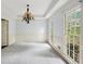 Elegant dining room with carpet, chandelier, natural light from windows, and white trim at 2650 Wendell Creek Ln, Snellville, GA 30039