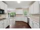Bright kitchen featuring stainless steel appliances, white cabinets, and dark wood flooring at 2650 Wendell Creek Ln, Snellville, GA 30039