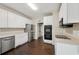 Charming kitchen featuring stainless steel appliances, white cabinets, and dark wood flooring at 2650 Wendell Creek Ln, Snellville, GA 30039