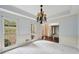 Bright living room with large windows, carpet floors, and decorative chandelier at 2650 Wendell Creek Ln, Snellville, GA 30039