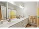 Bathroom with double sinks, tile floors, large mirror, and yellow accents at 2656 White Rock Dr, Buford, GA 30519