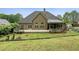 A home's rear exterior features a large deck, screened porch, well-maintained lawn, and landscaped garden beds at 2656 White Rock Dr, Buford, GA 30519