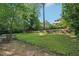 Spacious backyard featuring lush greenery and a stone patio seating area at 2911 Allegro Nw Dr, Atlanta, GA 30318