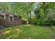 Private backyard featuring a brick exterior, mature trees, and lush greenery at 2911 Allegro Nw Dr, Atlanta, GA 30318