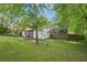 Cozy brick home featuring a lush green backyard, patio set, and mature trees at 2911 Allegro Nw Dr, Atlanta, GA 30318
