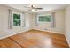 Cozy bedroom with a ceiling fan, hardwood floors, and natural light from two windows at 2911 Allegro Nw Dr, Atlanta, GA 30318