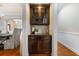 Charming bar area featuring dark wood cabinetry and glass shelving, perfect for entertaining at 2930 Burnt Hickory Nw Rd, Marietta, GA 30064