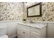 Elegant powder room with marble countertop, floral wallpaper, and white wainscoting at 2930 Burnt Hickory Nw Rd, Marietta, GA 30064