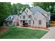 Charming two-story brick home featuring a lush green lawn, mature trees, and inviting curb appeal at 2930 Burnt Hickory Nw Rd, Marietta, GA 30064