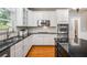 Modern kitchen features white cabinets, stainless steel appliances, dark countertops, and hardwood floors at 2930 Burnt Hickory Nw Rd, Marietta, GA 30064