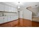 Kitchenette featuring modern cabinetry, stainless steel appliances, and hardwood floors, adjacent to the staircase at 2930 Burnt Hickory Nw Rd, Marietta, GA 30064