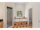 Bright bathroom with a shower, soaking tub under a window, and tiled floors at 3113 Brians Creek Se Dr, Conyers, GA 30013
