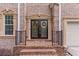 Close-up of a brick home's entrance, highlighting the double doors with decorative wreaths at 3113 Brians Creek Se Dr, Conyers, GA 30013