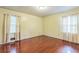 Bright bedroom featuring hardwood floors, neutral walls, and two windows draped with light curtains at 3430 Shorelake Dr, Tucker, GA 30084