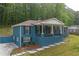 Charming blue house with a welcoming front porch and lush greenery in a serene, wooded setting at 3430 Shorelake Dr, Tucker, GA 30084