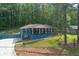 Charming blue home with a welcoming front porch and lush greenery in a serene, wooded setting at 3430 Shorelake Dr, Tucker, GA 30084