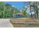 A charming blue brick home nestled amongst the trees, featuring a welcoming front porch and well-kept lawn at 3430 Shorelake Dr, Tucker, GA 30084