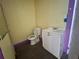 This bathroom features a toilet, sink, and vanity combination and black tile floors at 39 N Broad St, Covington, GA 30014