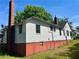 View of the rear of the house with a brick chimney and painted foundation at 39 N Broad St, Covington, GA 30014