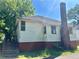 View of the rear of the house with a brick chimney and painted foundation at 39 N Broad St, Covington, GA 30014