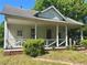 Exterior view of home with covered porch, showing potential for renovation and charm at 39 N Broad St, Covington, GA 30014