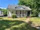 Charming single-story home with a front porch and mature trees and landscaping at 39 N Broad St, Covington, GA 30014