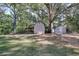 This spacious backyard features two storage sheds and is surrounded by mature trees at 4551 Salem Rd, Covington, GA 30016