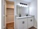 Dual vanity bathroom with white cabinets, granite countertop, and black fixtures, along with closet access at 4551 Salem Rd, Covington, GA 30016