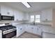 Updated kitchen with stainless steel appliances, attractive countertops, and ample natural light from a window at 4551 Salem Rd, Covington, GA 30016