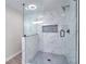 Glass enclosed shower features decorative tiles, a shower niche, and sleek black fixtures at 4551 Salem Rd, Covington, GA 30016