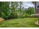 Spacious backyard featuring a well-maintained lawn, mature trees, and a charming wooden fence at 5595 Timson Ln, Johns Creek, GA 30022