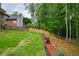 Large backyard with a well-manicured lawn, landscaped flowerbeds, and mature trees providing shade and privacy at 5595 Timson Ln, Johns Creek, GA 30022