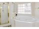 Bright bathroom features a soaking tub with gold fixtures and a glass shower enclosure at 5595 Timson Ln, Johns Creek, GA 30022