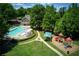 Aerial view of a community pool with a slide, playground, and inviting clubhouse at 5595 Timson Ln, Johns Creek, GA 30022