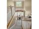 View of the staircase with carpet, white railings and a view of the dining room below at 5595 Timson Ln, Johns Creek, GA 30022