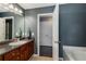 The bathroom has dark gray walls, granite countertops, wooden cabinets, and a tub at 72 Griggs Sw St, Marietta, GA 30064